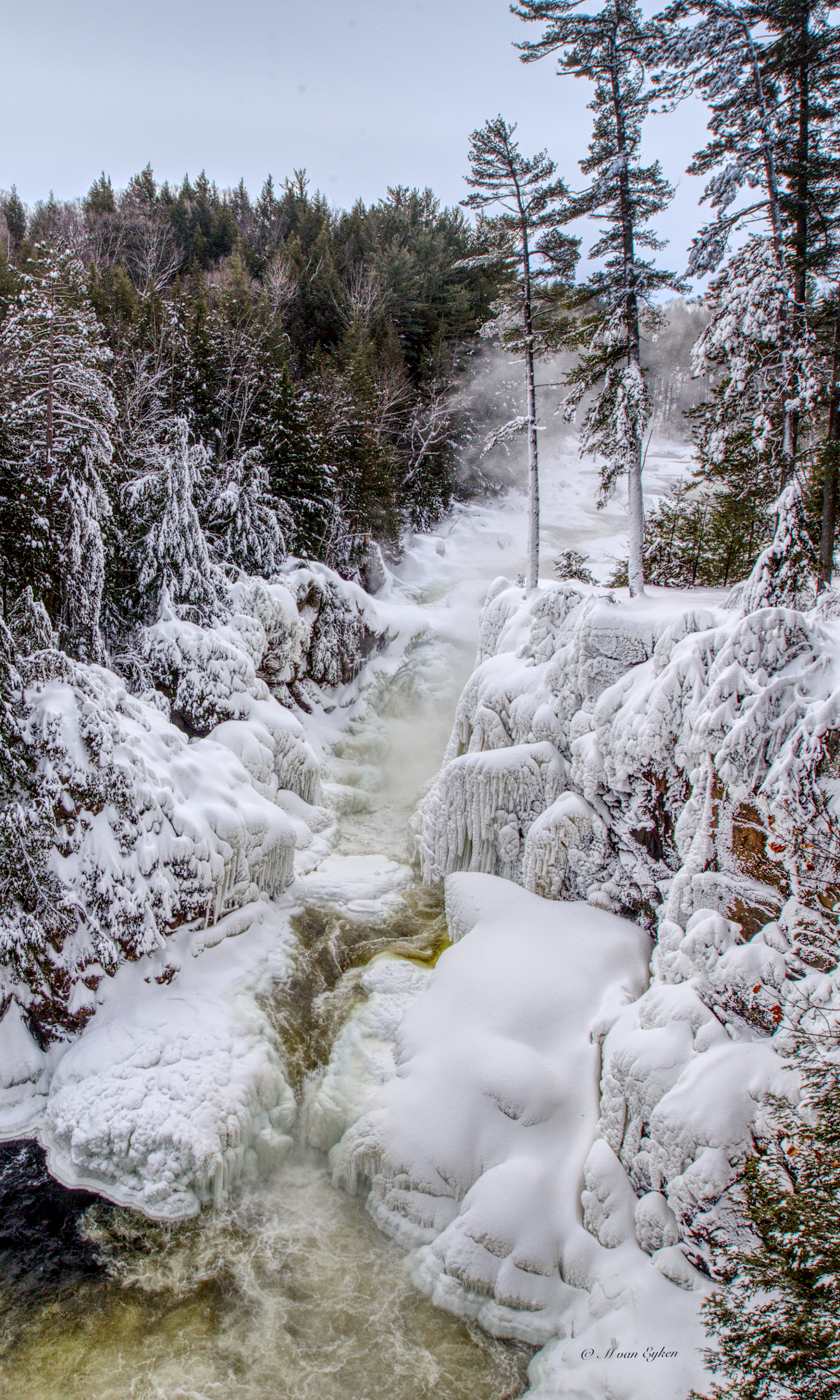 A partially frozen waterfall tears through an ice-laden gorge in the depths of a Quebec winter.
